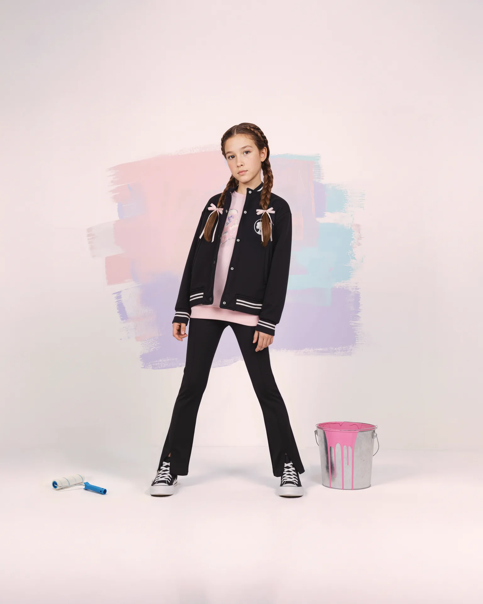 Barbie brunette girl in a black varsity jacket and flared trousers