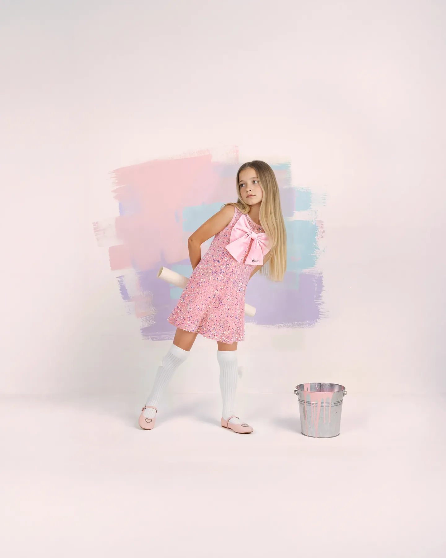 Barbie blonde girl in a pink sequin dress with a bow